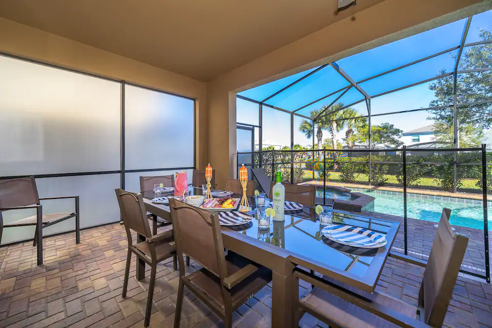 A view at the pool in an open surrounding with a table in the front