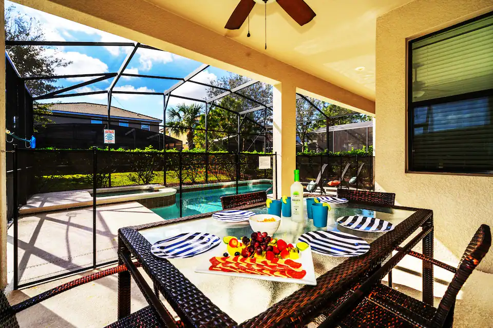 A view at the pool in an open surrounding with a table in front.
